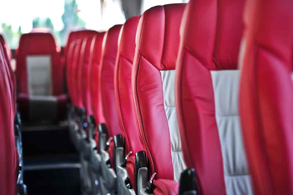 Rows of red and gray charter bus seats
