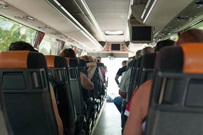 Rear view of passengers sitting in charter bus seats