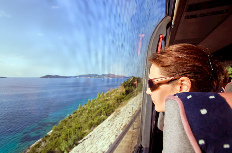 The woman in the bus looks out of the window on a sea landscape