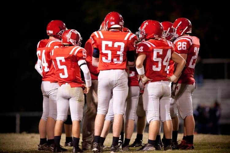 A high school football team huddling.