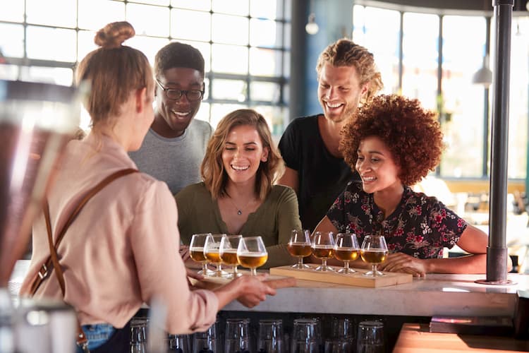Group of friends being served beer at brewery